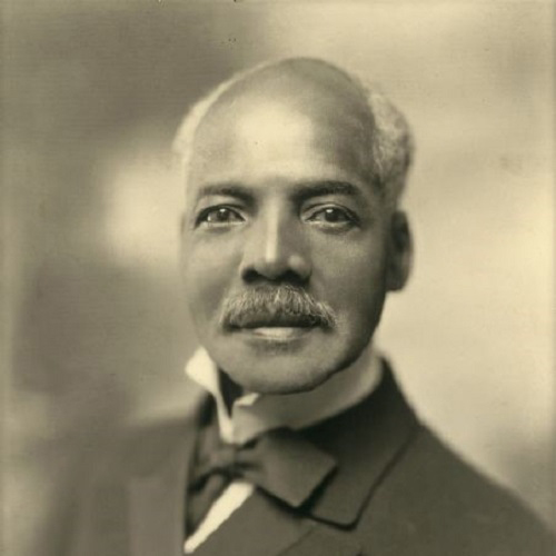 Studio portrait of Benjamin Butts wearing bow tie and suit circa 1930. He looks earnestly at the camera, mustache full and eyes twinkling.