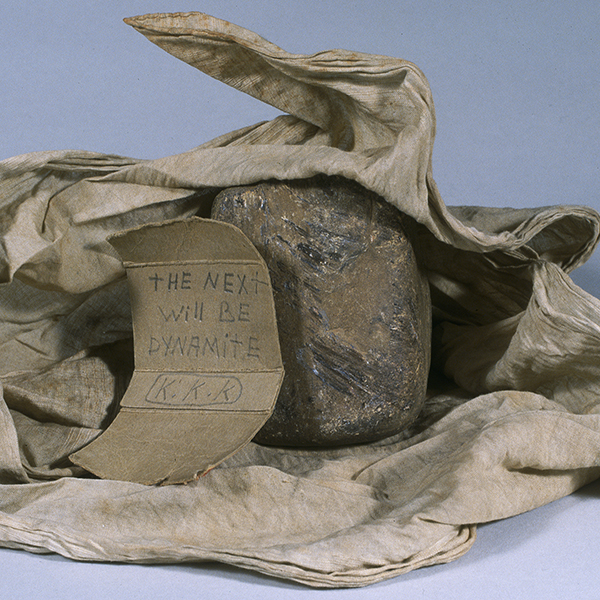 Threatening note signed 'K.K.K.' (Ku Klux Klan) with rock and rag that was thrown through Daisy Bates' window in August 1957. The note reads: 'The next will be dynamite.' 