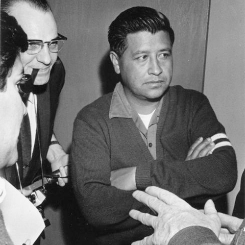 Cesar Chavez, the leader of United Farm Workers, is standing at the center of the photograph surrounded by members of the press. Behind him is a photographer with a pipe in his mouth and a camera in his hands. Besides him, someone is holding a pencil and paper taking notes. This is Chavez's first visit to Milwaukee to meet with Jesus Salas of Wisconsin's migrant farm worker union Obreros Unidos (United Workers) for El Centro Hispano-Americano to discuss agreement disputes between growers and farm workers. Strikes in Wisconsin were organized by the Obreros Unidos, an independent farm worker labor union effort in the 1960s.            Cesar Chávez en Wisconsin            Cesar Chávez líder de United Farm Workers, está parado en el centro de la fotografía rodeado de miembros de la prensa. Detrás de él está un fotógrafo con una pipa en su boca y una cámara en sus manos. A su lado, alguien está tomando notas con un lápiz y papel. Esta es la primera visita de Chávez a Milwaukee para conocer a Jesús Salas de Obreros Unidos, un sindicato de trabajadores agrícolas, para El Centro Hispano-Americano y para discutir acuerdos de disputa entre los agricultores y los trabajadores agrícolas. Las huelgas en Wisconsin fueron organizadas por Obreros Unidos, un esfuerzo independiente del sindicato de trabajadores agrícolas durante los años 1960.